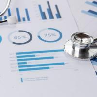 Graphs and medical data on a piece of paper under a stethoscope.