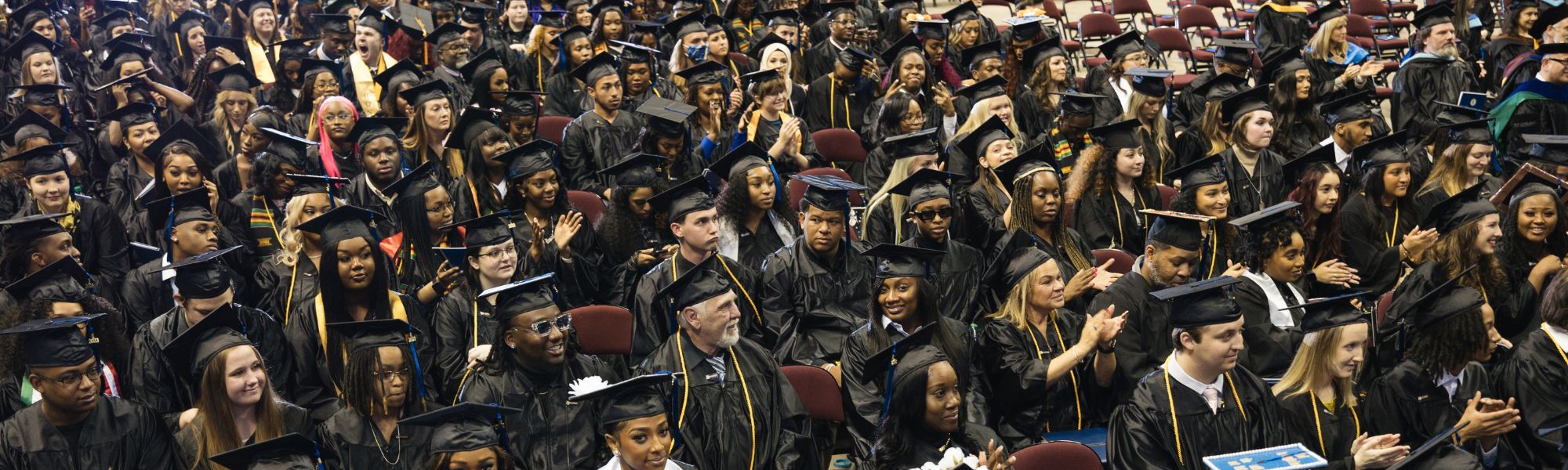 Crowd of graduates in caps and gowns at commencement.