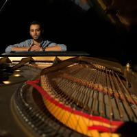 Theatre student leaning over piano