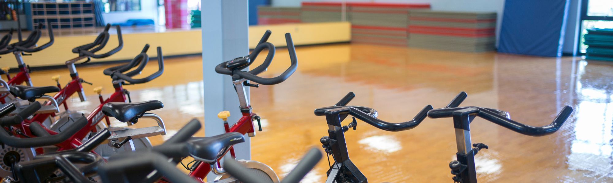 Exercise bikes lined up against a wall