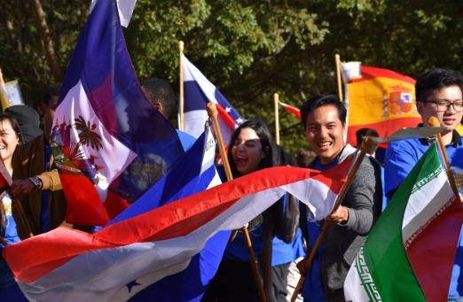 Smiling and laughing students waving international flags