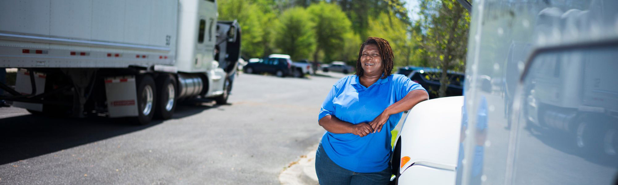 Truck driving student posing next to white semi truck